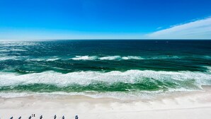 Una playa con olas y un cielo azul despejado.