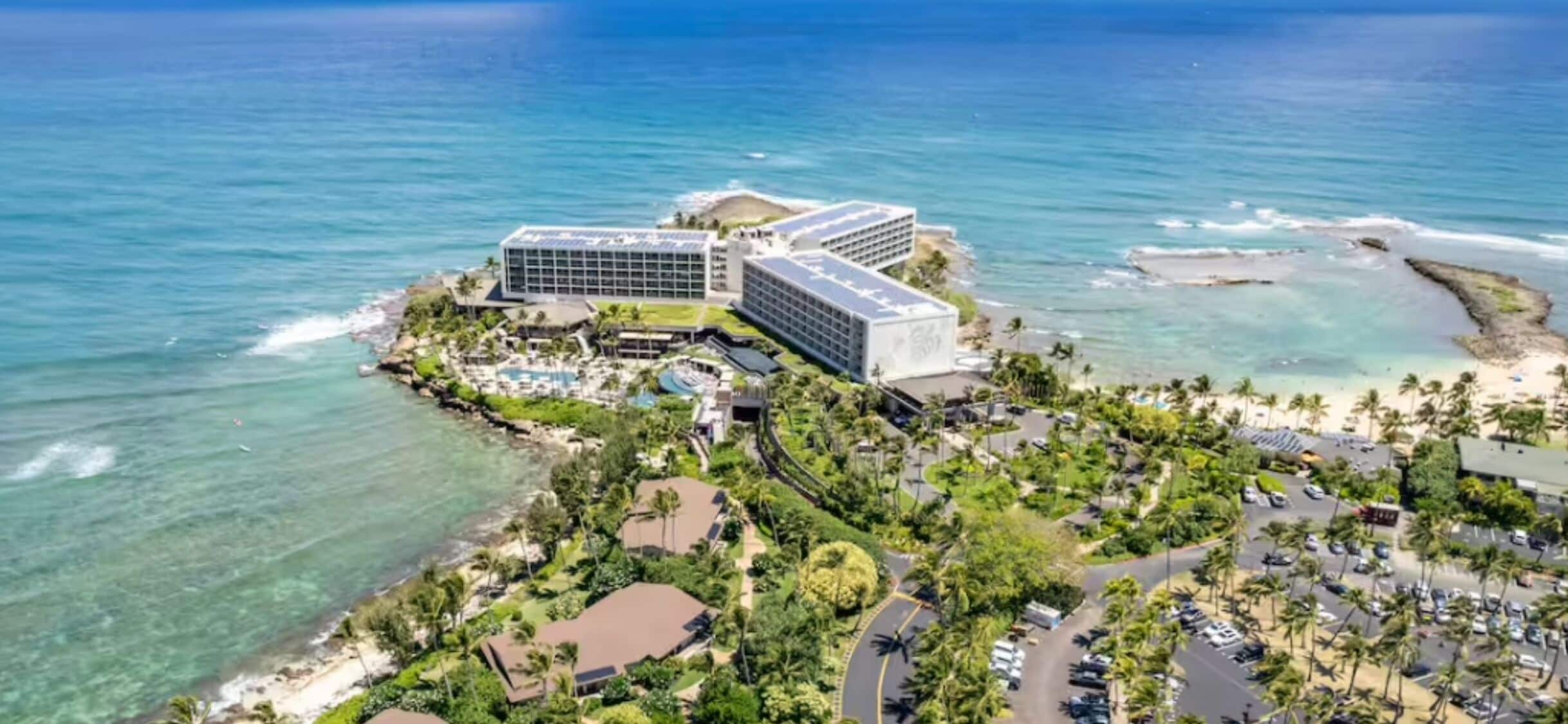 A coastal hotel with a pool, beachfront view, and multiple buildings.