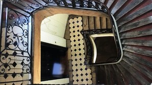 A spiral staircase with ornate metal railings and a patterned floor. - Studio in Paris, Le Marais (Paris)