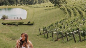 A woman walking in a vineyard with a lake and a wooden fence in the background. - ♨️Hot Tub🛏️King Bed🔥Fireplace 🍷Wineries🌲Oasis🥾Hike🌎Comfy🔥Fire Pit⛲Pond 🆒 (Dahlonega)