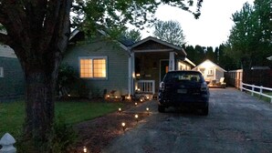 A residential driveway with a car parked in front of a house.