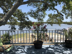 A wooden deck with potted plants and a bench overlooking a calm lake. - The Edgewater ~ New Dock ~ Spectacular Sunrises ~ Lots of Wildlife ~ Waterfront
 (Cedar Key)
