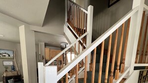 Una escalera con barandillas blancas y balaustres de madera que conduce a un piso superior.