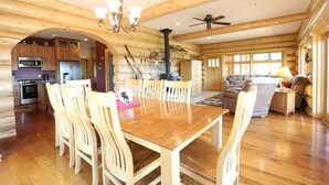 A spacious log cabin interior with a dining area, kitchen, and living space. - Secluded Log Home with Mountain View (Granby)