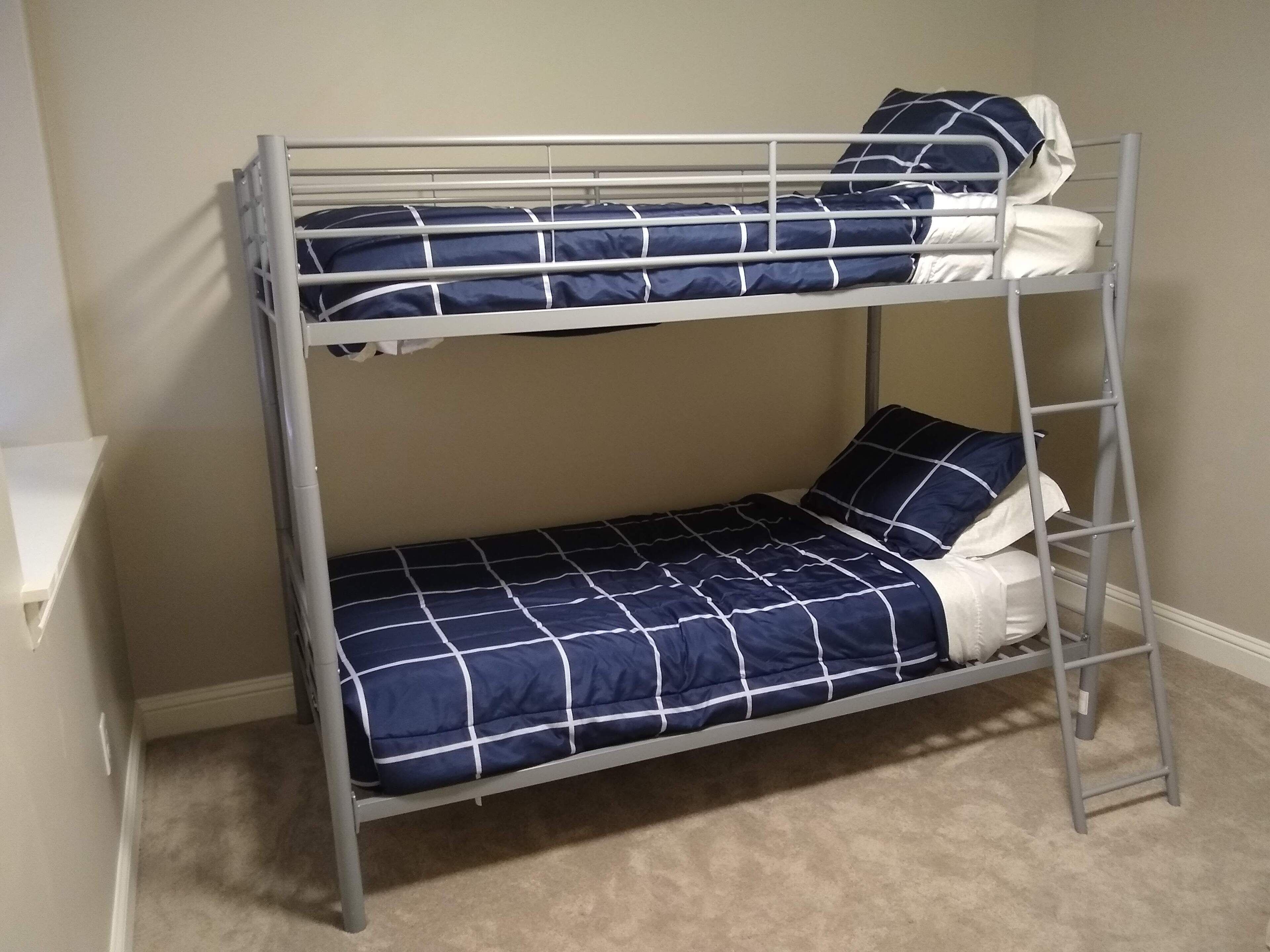 A bunk bed with a blue and white checkered bedspread and pillows.