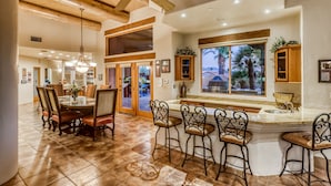 A spacious kitchen with a large island, bar stools, and a view of the outdoors. - Labor Day Available! Over the top!! Luxury, spacious, quiet family retreat. (Lake Havasu City)