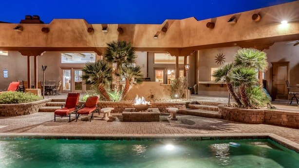 A pool area with red chairs, a fire feature, and palm trees. - Labor Day Available! Over the top!! Luxury, spacious, quiet family retreat. (Lake Havasu City)