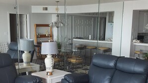 A modern living room with a dark leather sofa, a white coffee table, and a patterned rug. - Beautiful Oceanfront  Condo- Crescent Shores - Privately Owned and Maintained (North Myrtle Beach)