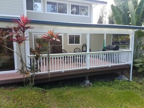 A house with a covered porch, a grill, and a dining area with chairs. - Spacious, 5 bd/3 ba home in Orchidland Estates (Pāhoa)