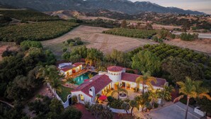 Una extensa propiedad con varias construcciones, piscina y abundante vegetación.