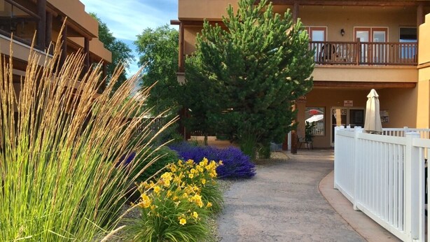 A building with a flat roof, a balcony, and a gravel pathway. - Experience a great family vacation at Casa Del Mila Oro ! (Osoyoos)