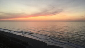 A beach with a sunset over the ocean. - Brand New Reno! OF, End Unit, King bed, Quartz Counters, Shaker Cabinets (Myrtle Beach)