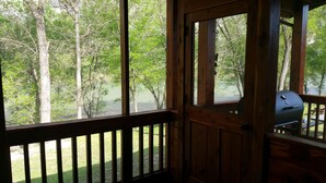 Una cabaña de madera con un balcón y vistas a un bosque.