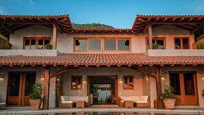 A two-story house with a swimming pool in front, wooden balconies, and potted plants. - Luxurious Troncones Beachfront! 30mins to Ixtapa (Troncones)
