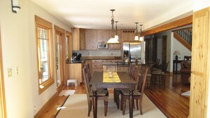 A spacious kitchen with wooden cabinets, a central island, and a dining area with a table and chairs. - Golf Course/Lodge Style/large/clean/comfortable/5 BR (Black Butte Ranch)