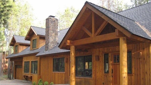 A log cabin with a stone chimney, wooden exterior, and a stone-paved entrance. - Golf Course/Lodge Style/large/clean/comfortable/5 BR (Black Butte Ranch)