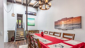 A dining area with a red tablecloth, wooden chairs, and a chandelier. - Spacious Beach House (Solana Beach)