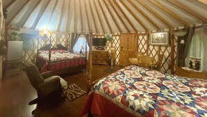 Una carpa amplia con una cama, un escritorio y una silla.