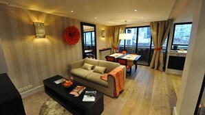 Een moderne woonkamer met een bank, salontafel en eethoek.