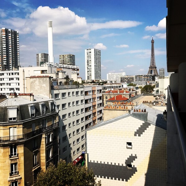 A cityscape with the Eiffel Tower in the background, modern buildings, and a view of the sky.