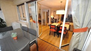Een moderne woonkamer met een glazen deur naar een eetgedeelte.