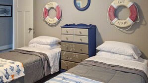 Ein Schlafzimmer mit zwei Betten, einem Schminktisch und Rettungsringen an der Wand.