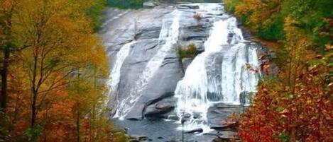 Ein Wasserfall, umgeben von Herbstlaub.