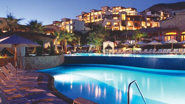 A resort pool area with lounge chairs and umbrellas, surrounded by multi-story buildings with balconies. - 4966sf Penthouse Great Ocean Views +25% Off Golf (Los Cabos, Cabo San Lucas Centro)