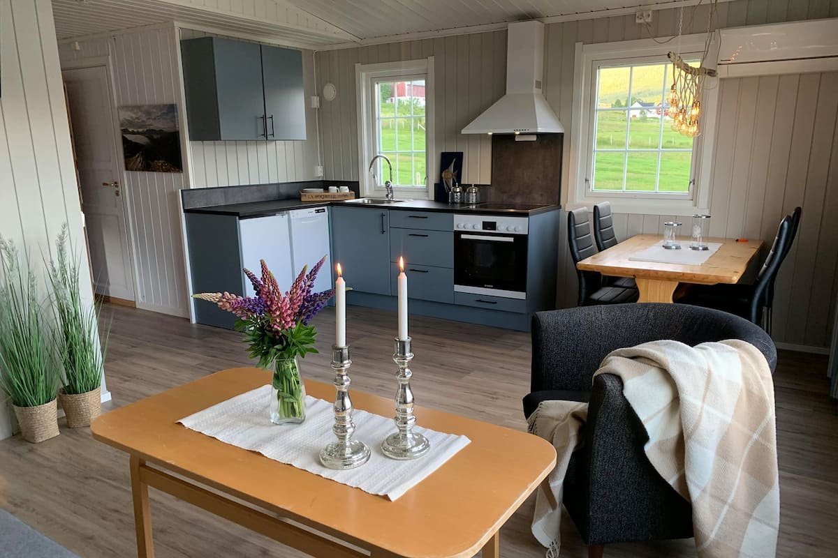 A modern kitchen with a built-in oven and a dining area with a table and chairs.