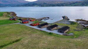 Un pueblo costero con edificios rojos, un muelle y barcos.