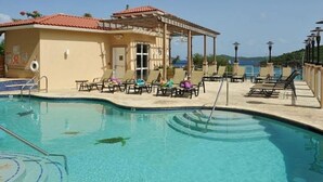 Una piscina con lettini e una zona riparata.