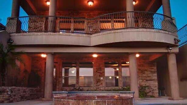 Un edificio de varios pisos con una piscina delantera.