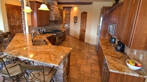 Una cocina con encimera de granito, estufa integrada y armarios de madera.