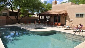 Une piscine dotée d’un espace pour bronzer, de chaises longues et d’un coin salon abrité.