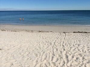 A sandy beach with footprints leading to the water. - Keybiscayne Charmer half a block from private Beach, Restaurants and Boutiques!! (Key Biscaine)