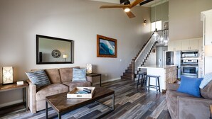 A spacious living area with a sofa, coffee table, and a kitchen in the background. - Fantastic Ocean View Steps to Kamaole Beach 3 (Kihei)