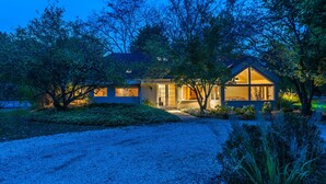 Ein modernes Haus mit einem gepflegten Garten, einer Auffahrt und einer großen Garage.