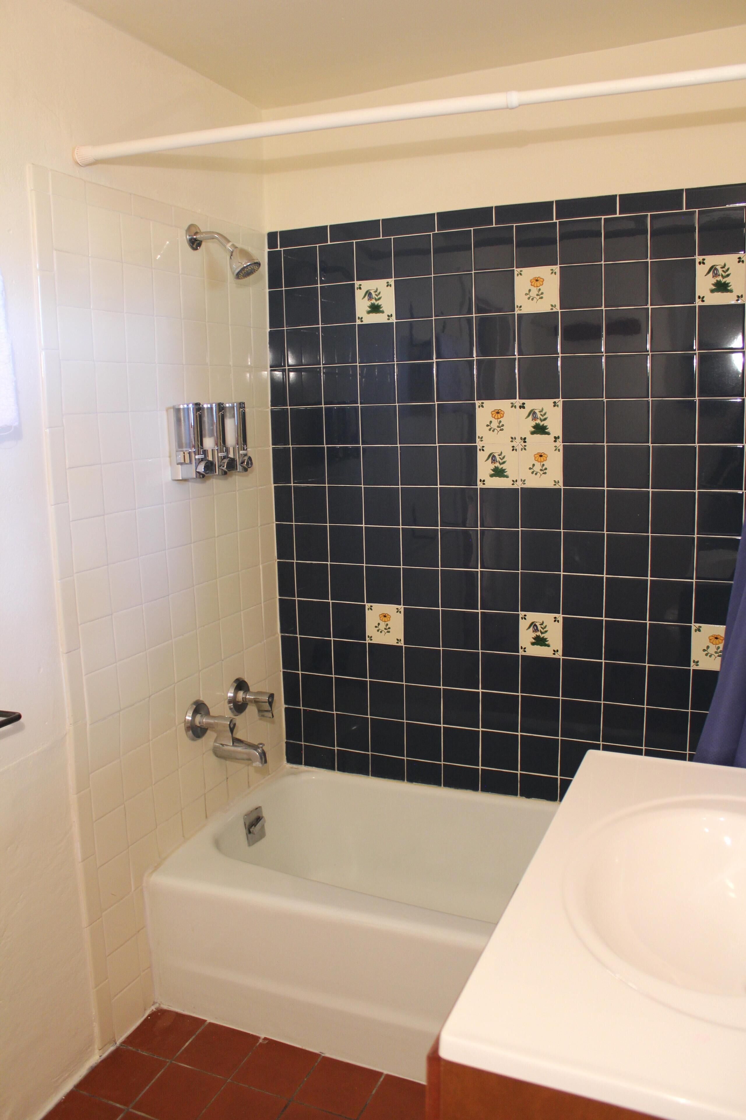 A bathroom with a bathtub, a shower, and a sink.