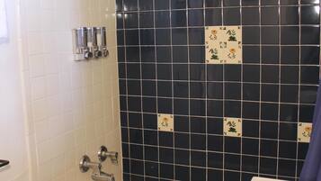 A bathroom with a bathtub, a shower, and a sink.