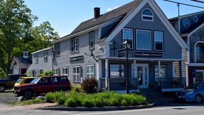 A two-story building with a sign reading "Edward Jones Investments" on the front. There are parked vehicles in front, including a red SUV and a blue car. - Maine Midcoast Vacation at Lincolnville Beach (Lincolnville)