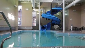 An indoor swimming pool with a blue water slide and a diving platform. - Amazing Penthouse-Private Hot Tub #5 of 5 - 405 (Canmore)