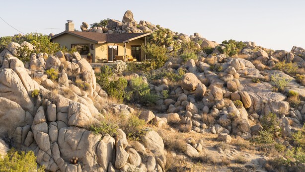 Una casa sobre una ladera rocosa con vistas despejadas del paisaje circundante.