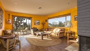 Un salón amplio con un ventanal grande, chimenea y una zona de estar acogedora.