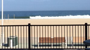 A beach view with a fence, a bench, and a trash can. - Ocean Front 1st Floor walkout to 25'x50' deck on the Boardwalk/Beach at 4th St (Ocean City)