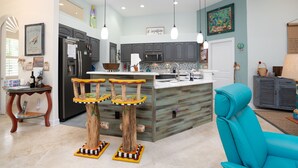 Una cocina moderna con una isla central, armarios grises e iluminación colgante.