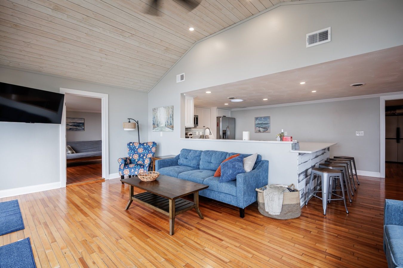 A spacious living area with a sofa, a coffee table, and a kitchen in the background.