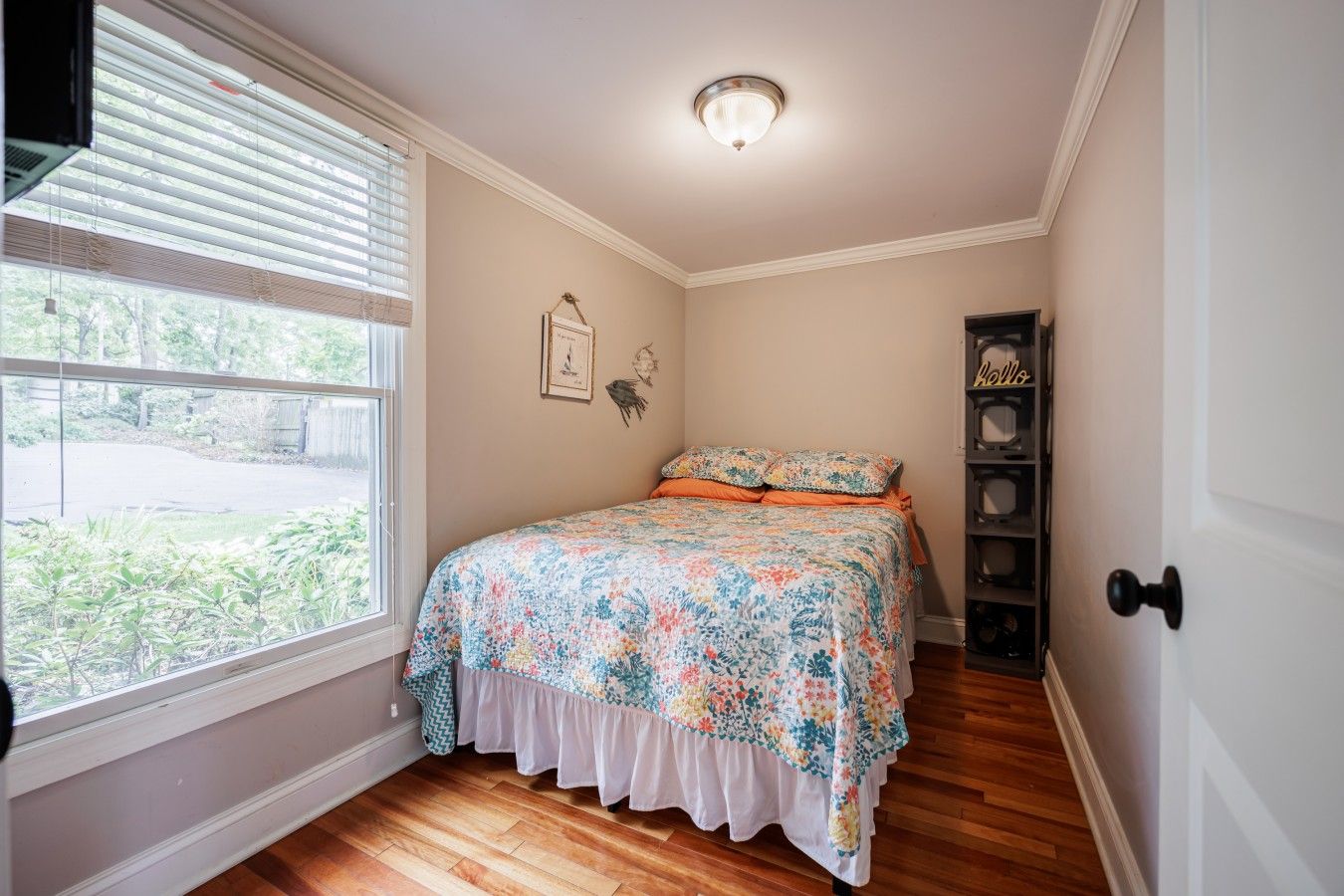 Quarto com cama, janela, porta e luminária no teto.