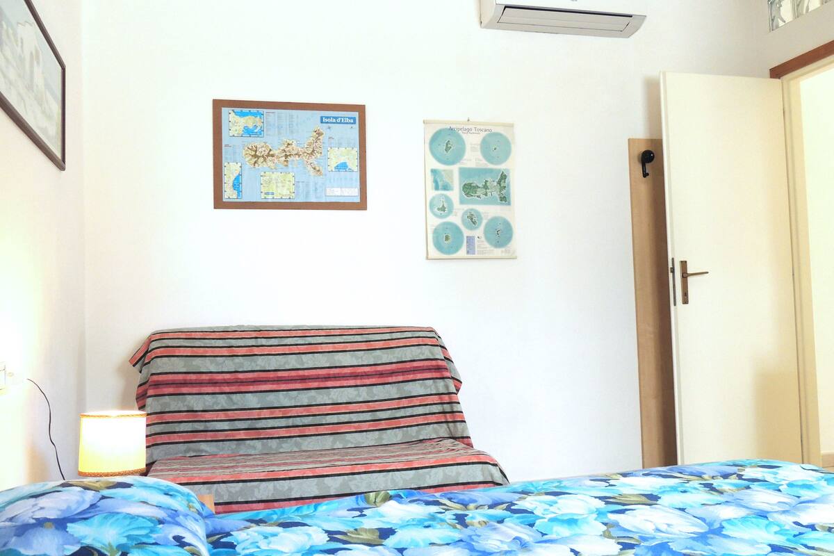 Ein Schlafzimmer mit einem Bett, einer Karte an der Wand und einer Tür.