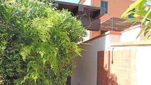 A garden area with dense foliage and a tiled wall. - Appartamenti Montecristo e Pianosa (Campo nell'Elba)