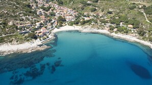 An aerial view of a coastal town with buildings along the shoreline and a large bay. - Appartamenti Montecristo e Pianosa (Campo nell'Elba)